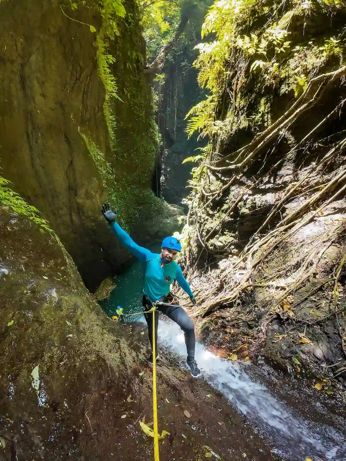 A guest rappelling a jungle waterfall on rope during the Aling Venture Route canyoning trip