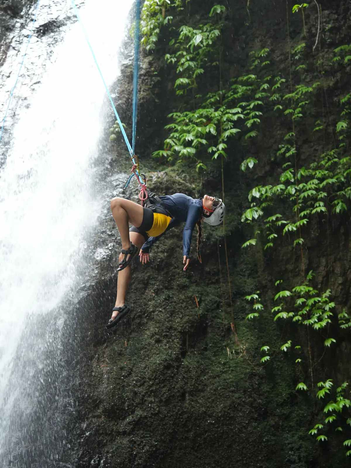 Freestyle pose hanging from the rope at Gitgit Waterfall