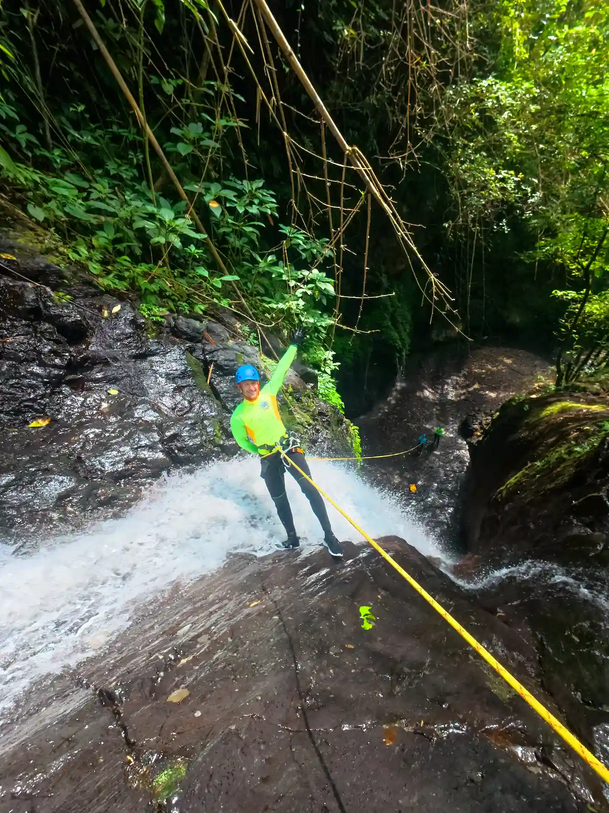 Guest cheering while rappelling a small waterfall on the Splash Canyon canyoning taster