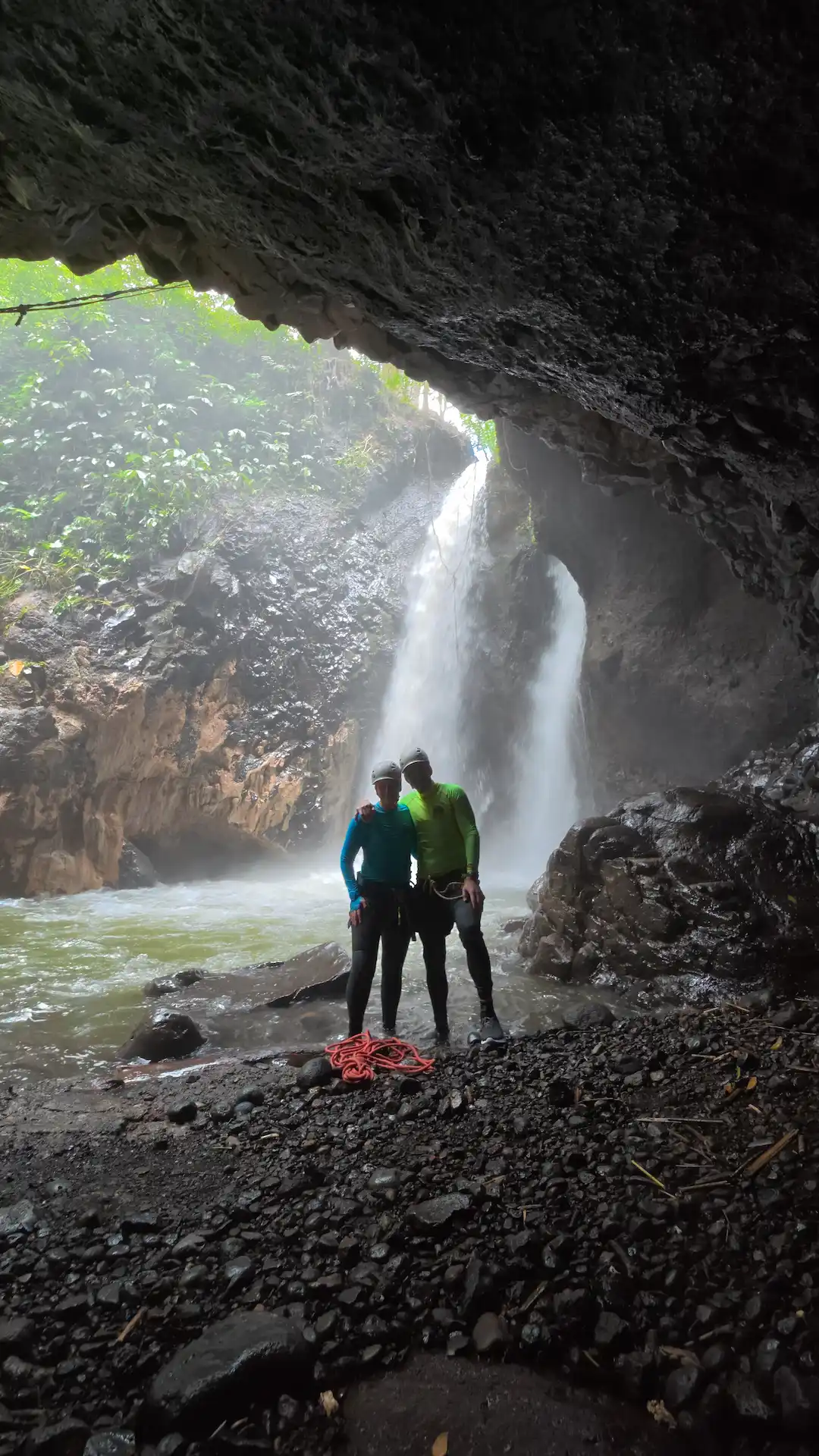 Two adventurers celebrating in front of a North Bali waterfall