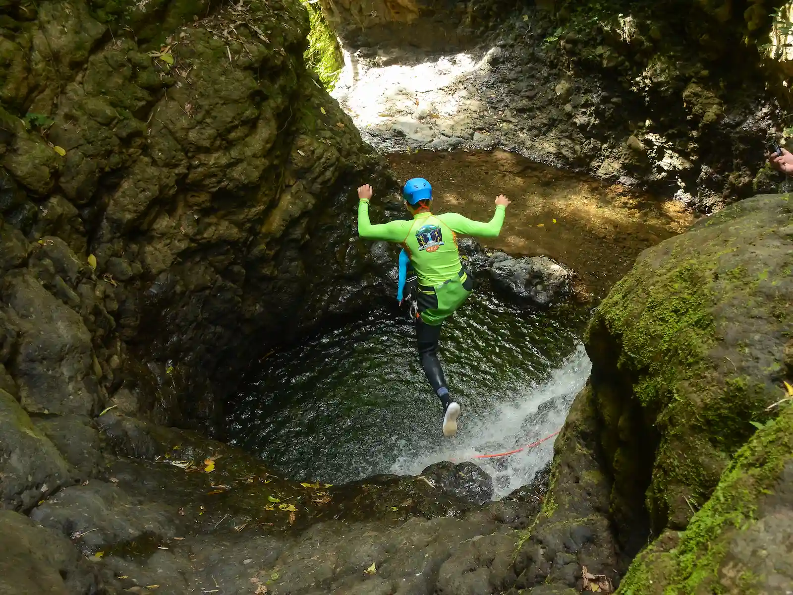 A canyoner taking an optional jump into a deep pool in Bali